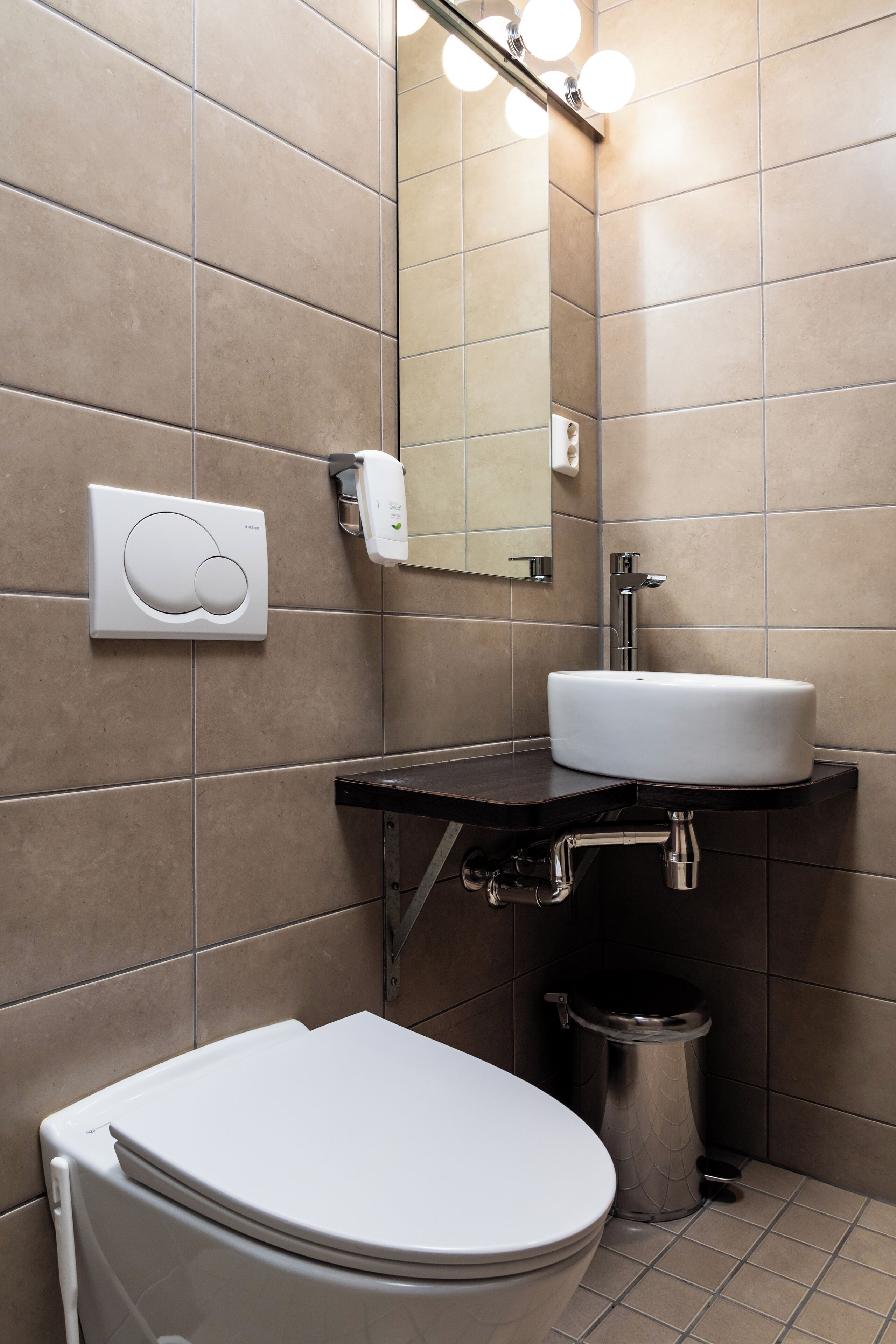 A modern bathroom with a white toilet, a sink, and a mirror.