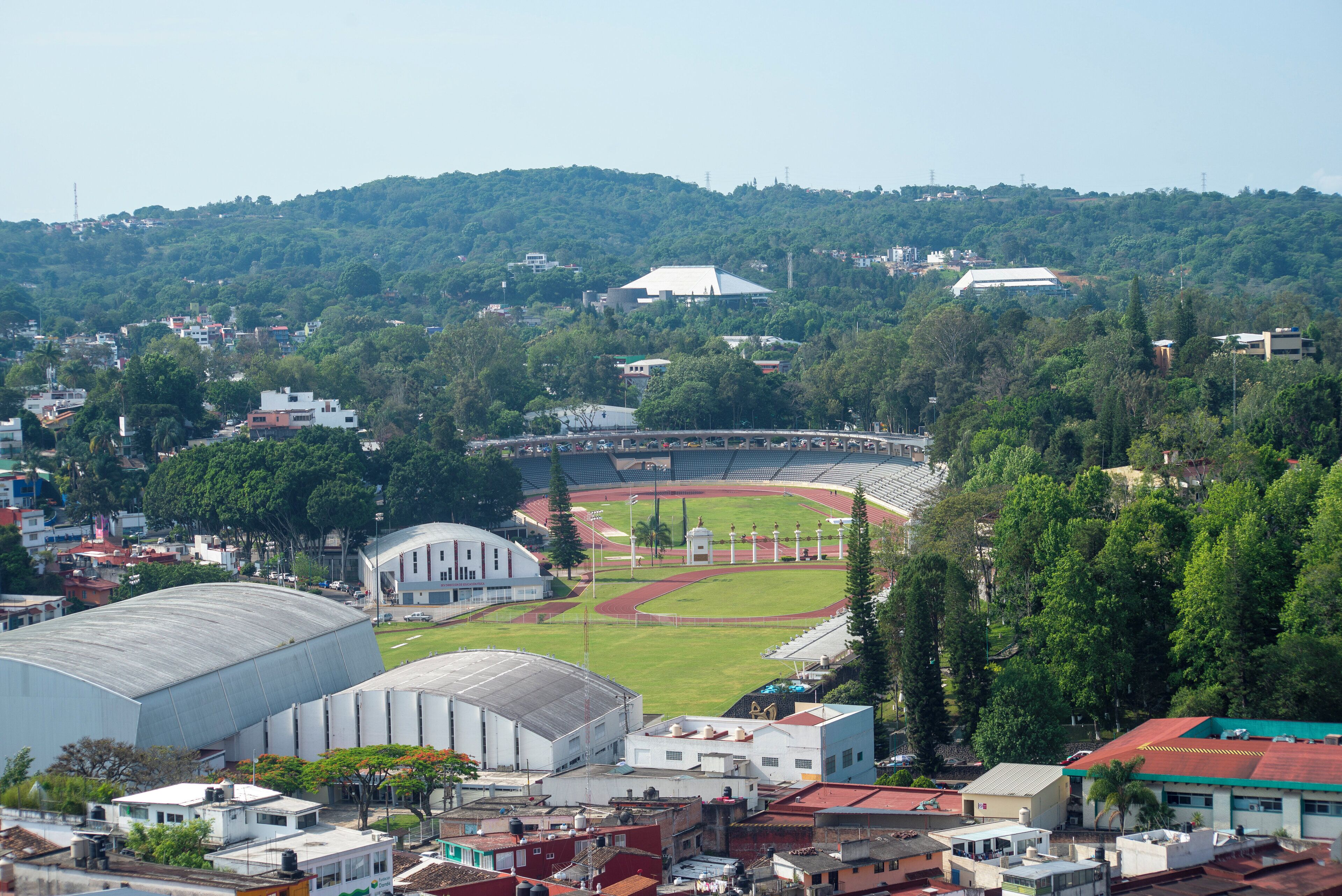 Un stade doté d’une piste d’athlétisme et de gradins, entouré d’immeubles résidentiels et d’espaces verts.