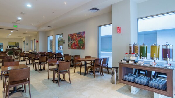 A spacious restaurant with multiple tables and chairs, a coffee station, and large windows offering views. - Holiday Inn Express Xalapa by IHG (Xalapa)