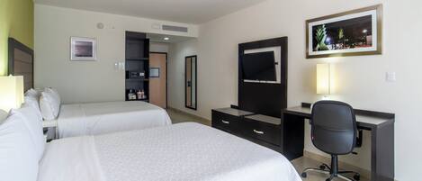 Habitación de hotel con dos camas, un escritorio, una silla, un espejo, un televisor y un cuadro en la pared.