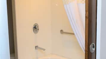 Un baño con bañera, ducha y puerta de cristal.