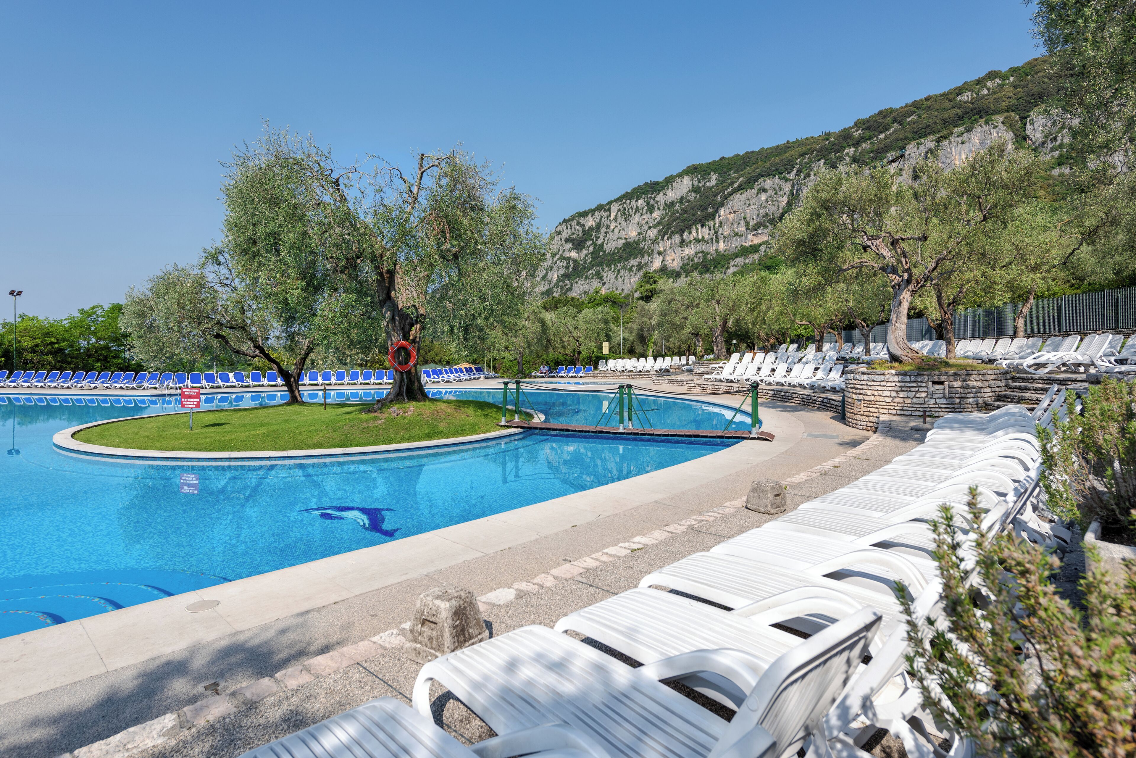 A swimming pool with lounge chairs and a lifeguard stand.