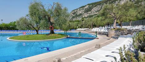 A swimming pool with lounge chairs and a lifeguard stand.