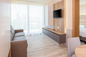 Deluxe Apartment | Living area | 20-inch TV with satellite channels - Residence Parco del Garda (Garda)