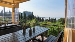 Una mesa de madera con plantas en macetas y vistas a un paisaje montañoso.