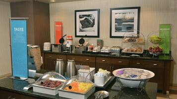 A buffet setup with various food items and a coffee station.
