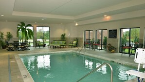 An indoor swimming pool with a clear water line, surrounded by lounge chairs and tables. - Hampton Inn Springfield-Southeast (Springfield)