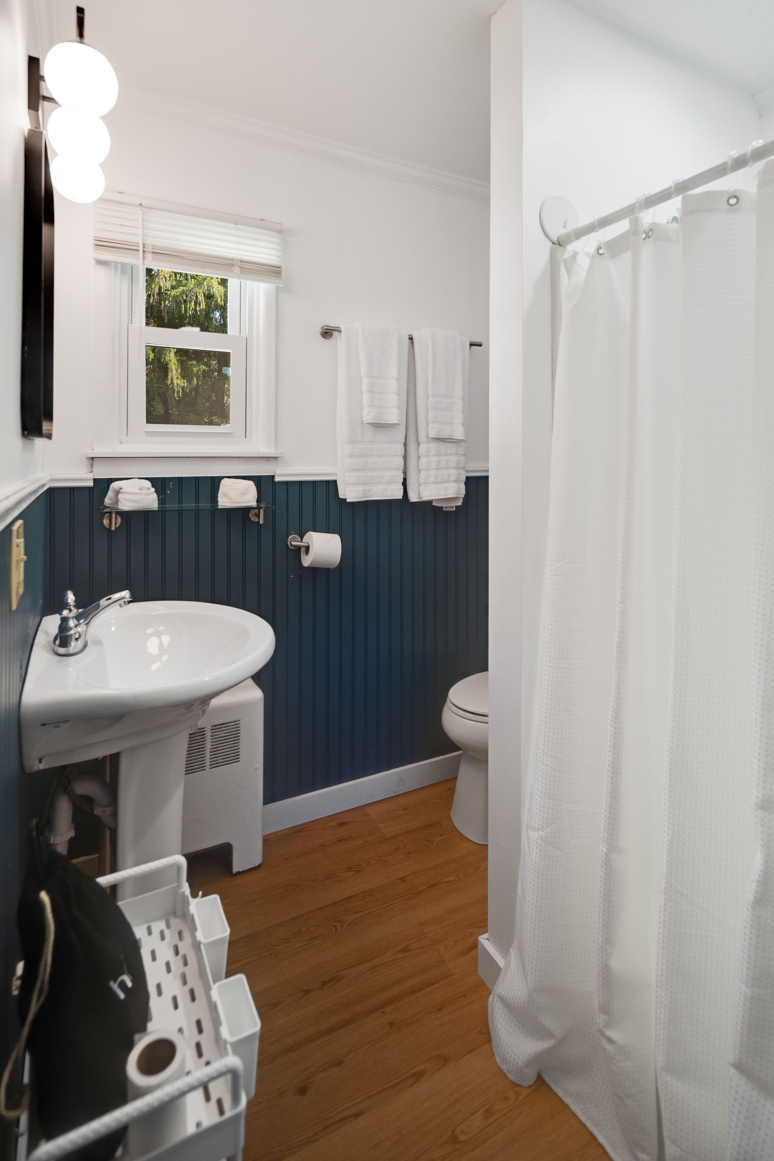 A bathroom with a white sink, a toilet, and a shower curtain.