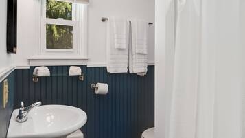 A bathroom with a white sink, a toilet, and a shower curtain.