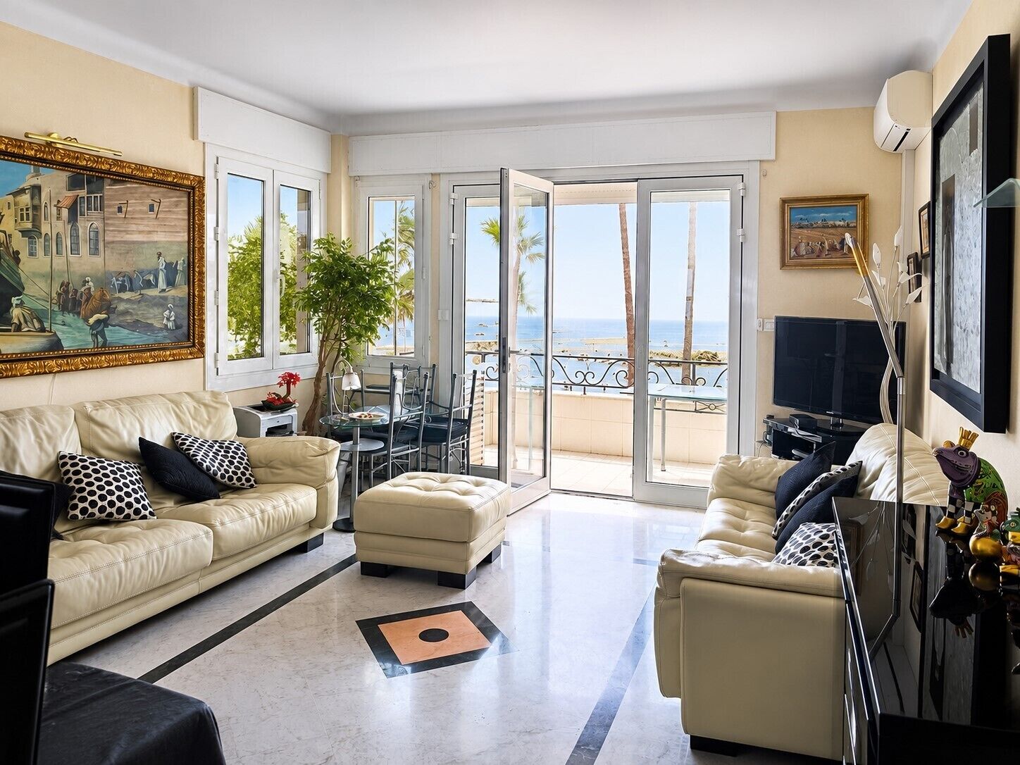 A spacious living room with a large window, a dining area, and a flat-screen TV.
