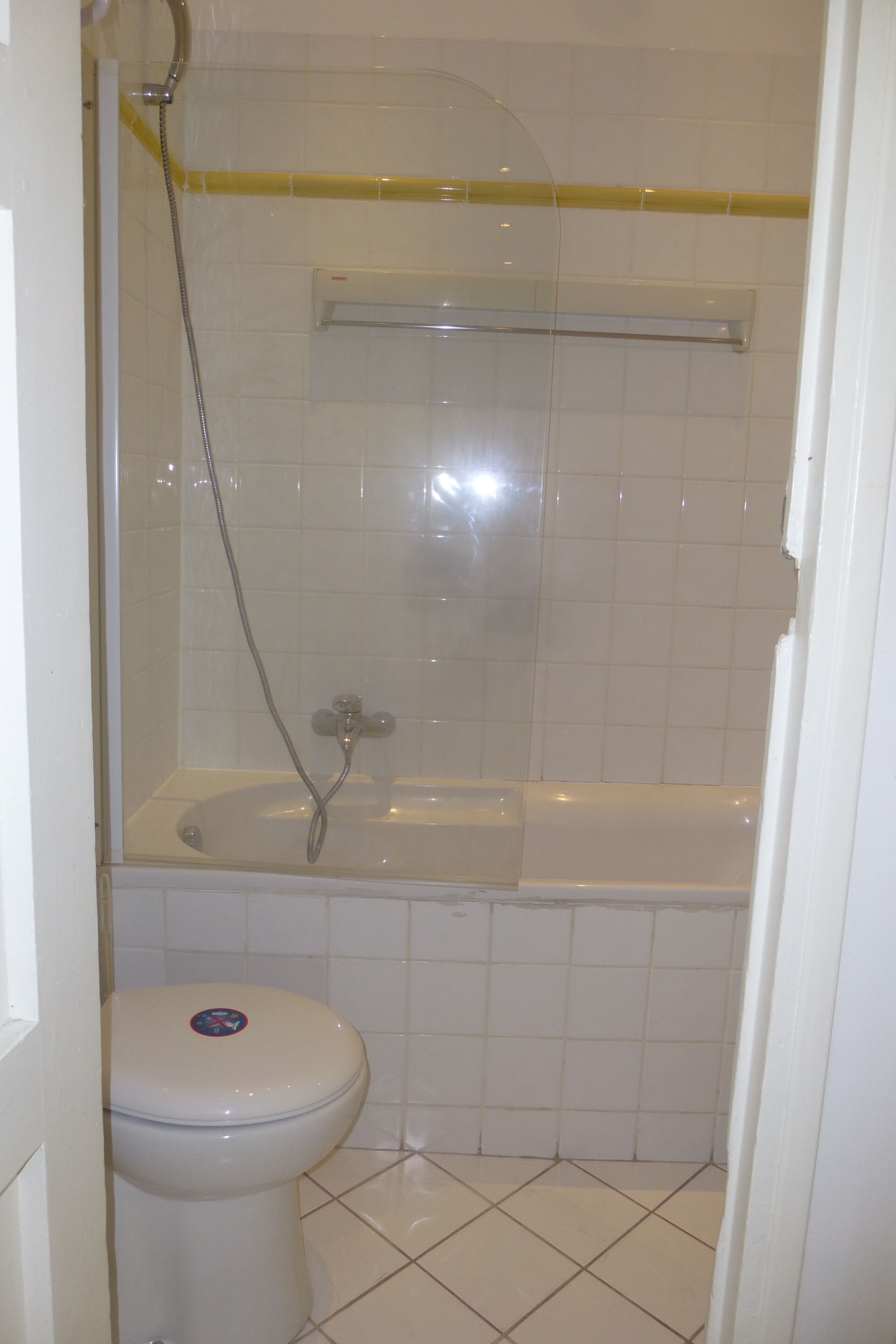 A bathroom with a toilet, a bathtub, and a shower enclosure.