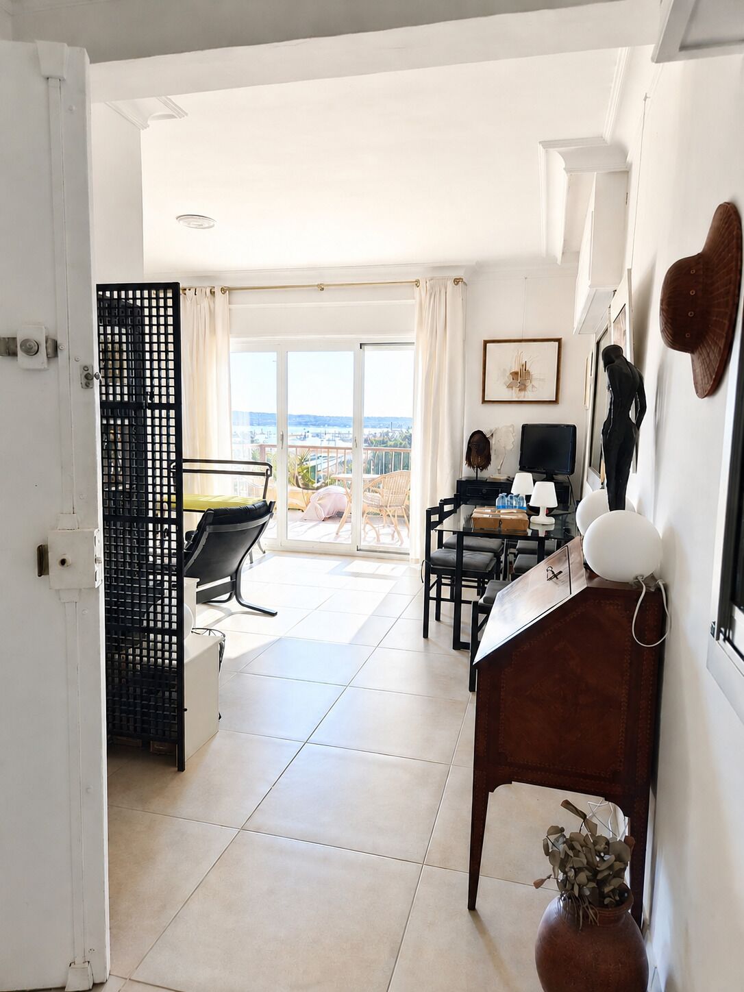 Una habitación de hotel moderna con balcón, escritorio y zona de comedor.