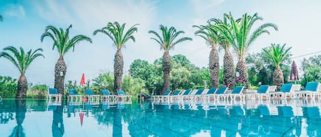 Piscine extérieure, parasols de plage, chaises longues