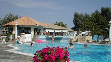 Relax by the pool, where guests can swim and lounge on comfortable sunbeds under a shaded area.