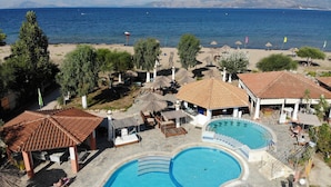 Un complexe hôtelier doté d’une piscine, d’une plage et de parasols.