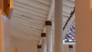 Un pasillo con columnas blancas y suelo de baldosas.