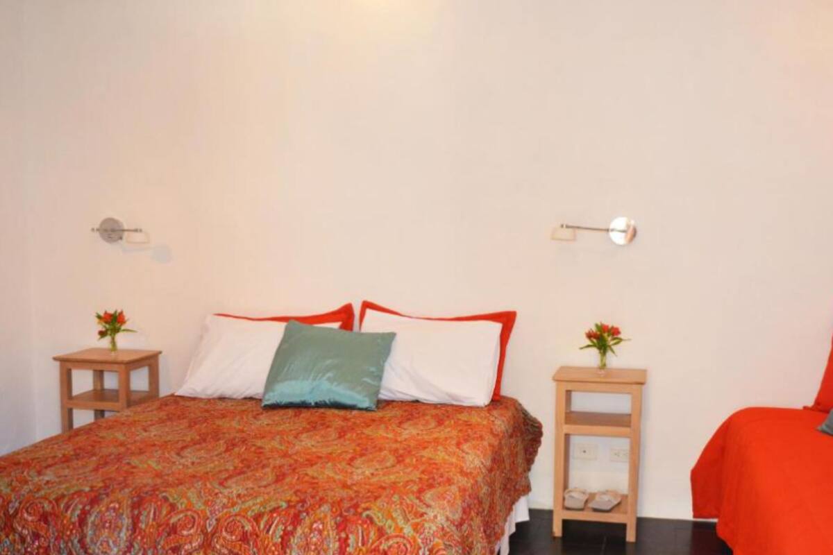 A bedroom with a bed, two bedside tables, and a nightstand.