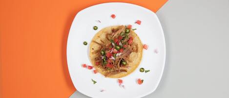 A plate with a taco on a white plate, surrounded by a geometric background.