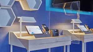 A modern reception desk with a laptop, a mobile phone, and a cash register. - One Monclova Hotel (Monclova)
