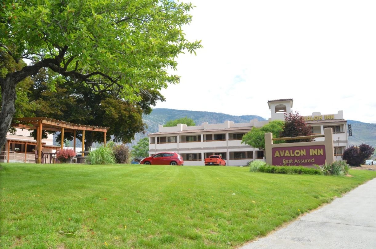 A hotel with a sign reading "Avalon Inn Rest Assured."