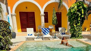 Ein Poolbereich mit Liegestühlen und einer Palme.