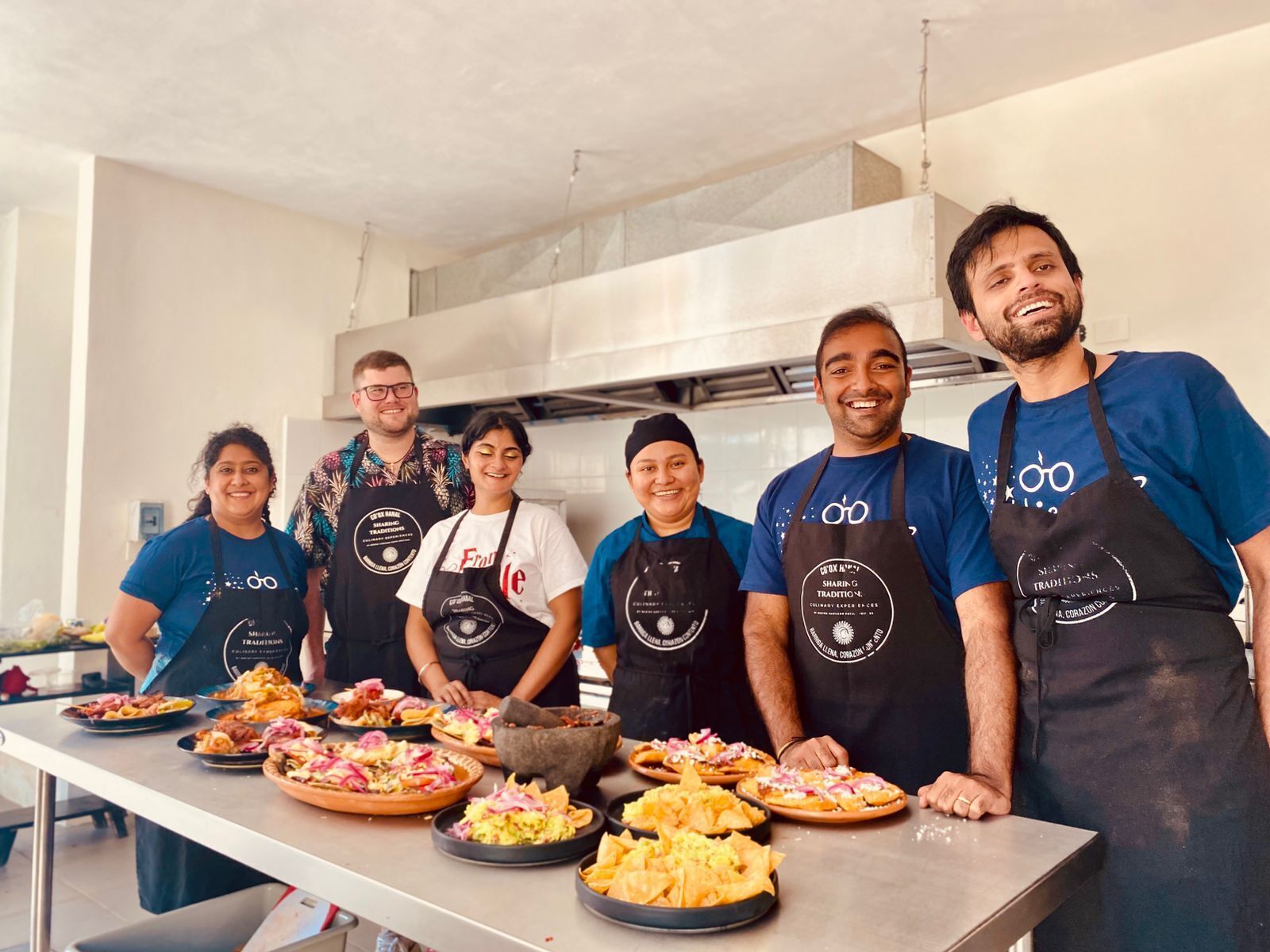 A group of people in a kitchen with various dishes on the counter.