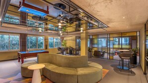 A modern indoor space with a pool table, a sectional sofa, and a billiards table. - Royal Regency Paris Vincennes (Vincennes)