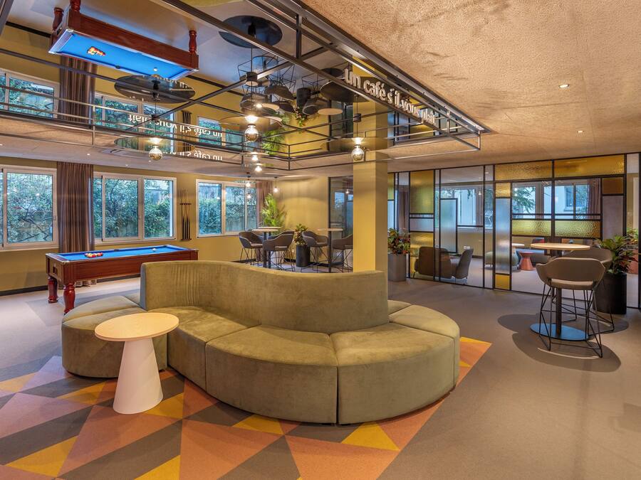 Un espacio interior moderno con mesa de billar, sofá seccional y mesa de futbolín.