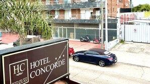 A hotel named "Hotel Concorde" with a signboard, a multi-story building with balconies, and a parked car. - Hotel Concorde (Punta del Este)