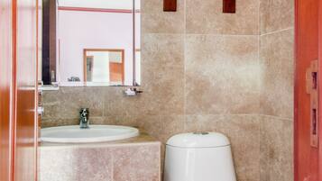 A bathroom with a sink, toilet, and a towel rack.