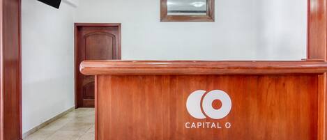 Un mostrador de recepción con detalles de madera y un cartel que dice "RECEPCIÓN".