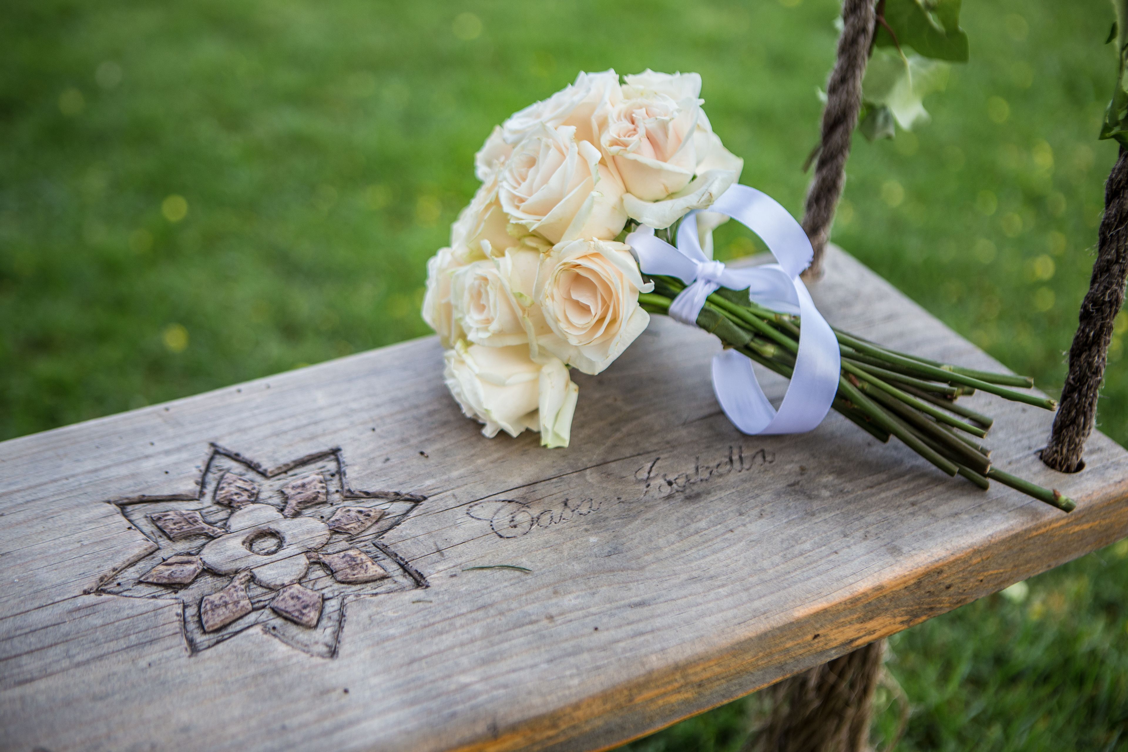 A wooden bench with a carved star design and the name "Gabe & Isabella" engraved on it.