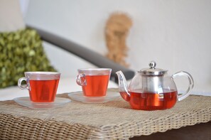 A clear glass teapot and two cups of tea on a woven mat. - Hotel Boutique Casa Isabella (Tepoztlán)