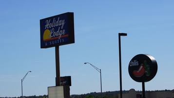Letrero de Holiday Lodge con un logo de sol y luna, un logo de Chili's y un letrero de Pizza Hut.