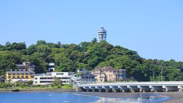 A coastal town with a prominent tower, a bridge, and buildings along the waterfront.