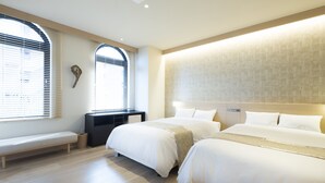 A modern hotel room with two beds, a bench, a desk, and large windows with blinds. - Fujisawa Hotel En (Fujisawa)