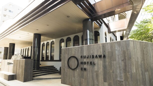 The exterior of the Fujisawa Hotel EN with a modern design, featuring a prominent entrance with steps and a large sign. - Fujisawa Hotel En (Fujisawa)