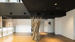 A spacious lobby with a wooden floor, a reception desk, and a unique art installation. - Fujisawa Hotel En (Fujisawa)