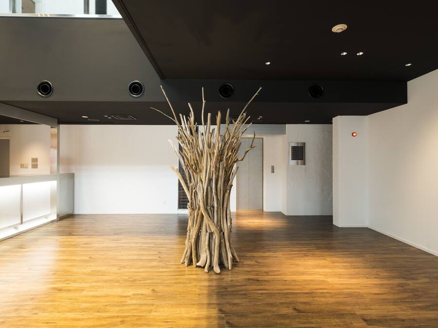 Eine großzügige Lobby mit Holzboden, einer Rezeption und einer einzigartigen Kunstinstallation.