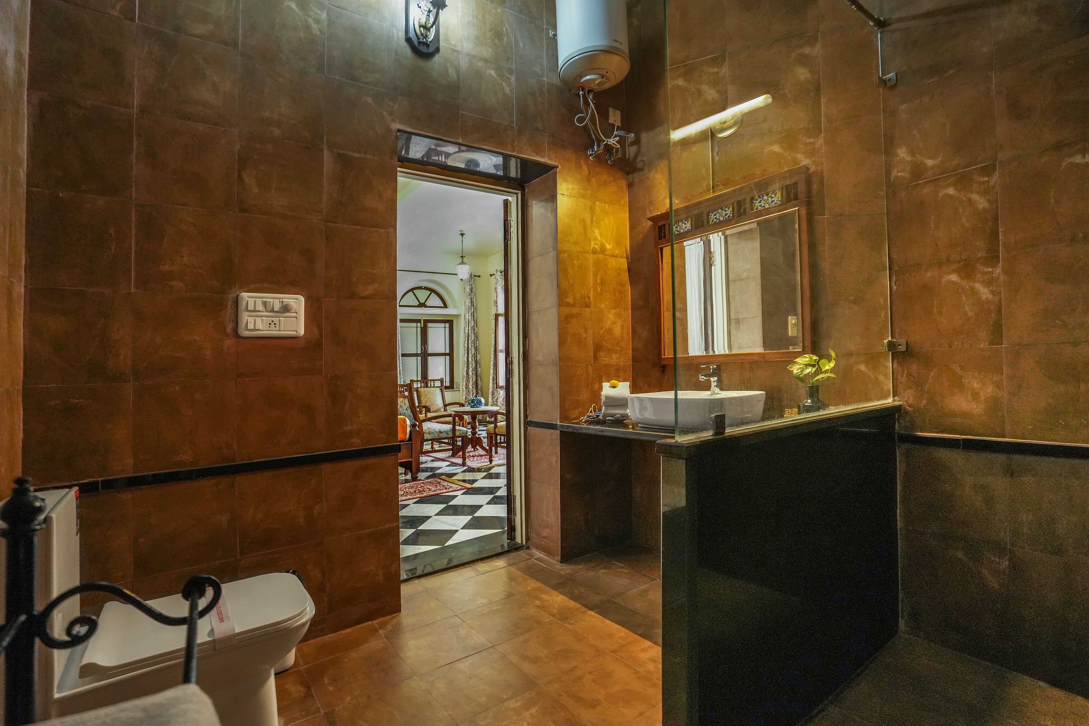 A bathroom with a toilet, sink, and mirror.
