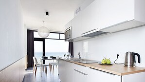 Una cocina moderna con armarios blancos, encimera de madera y vistas al exterior.