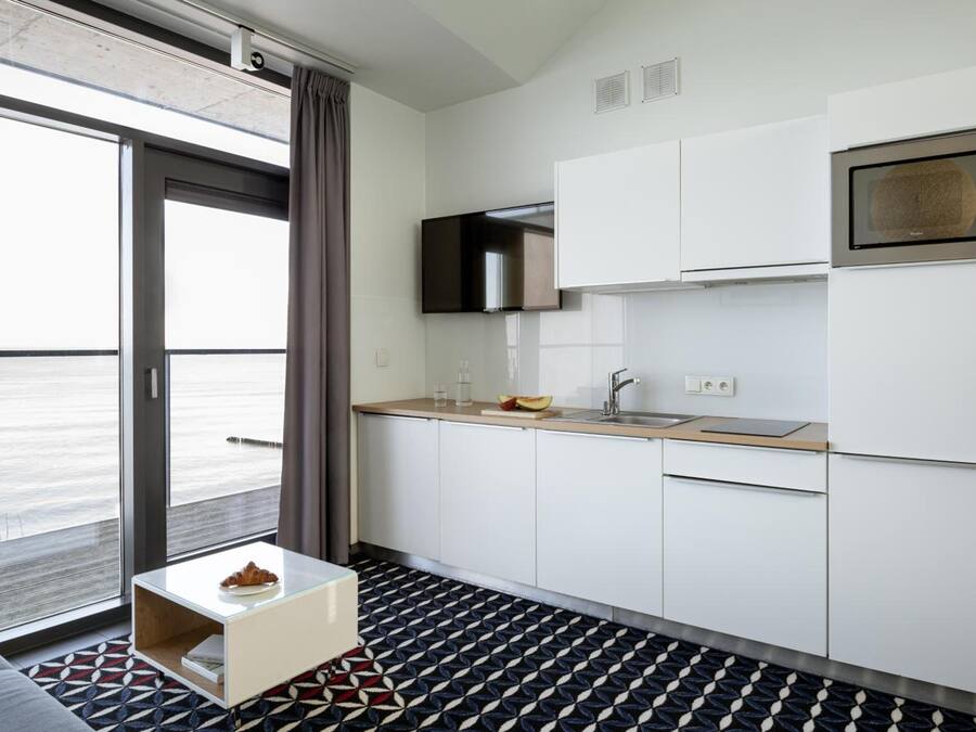A modern kitchen with a large window, a microwave, and a sink.