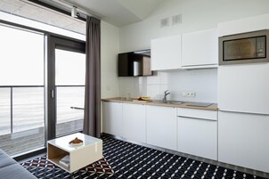 Una cocina moderna con un amplio ventanal, un microondas y un lavamanos.