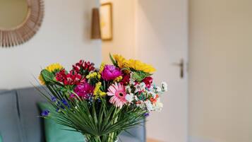 A bouquet of colorful flowers in a white vase on a table.