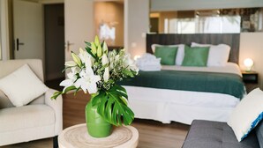 A hotel room with a bed, a sofa, a chair, and a vase of flowers. - H.Boutique la Caleta bay (Almunecar)