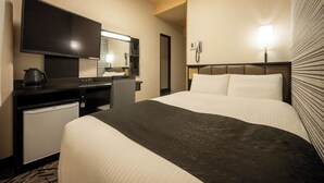 A hotel room with a bed, a desk with a television, a mini-fridge, and a telephone. - APA Hotel Isesakieki Minami (Isesaki)