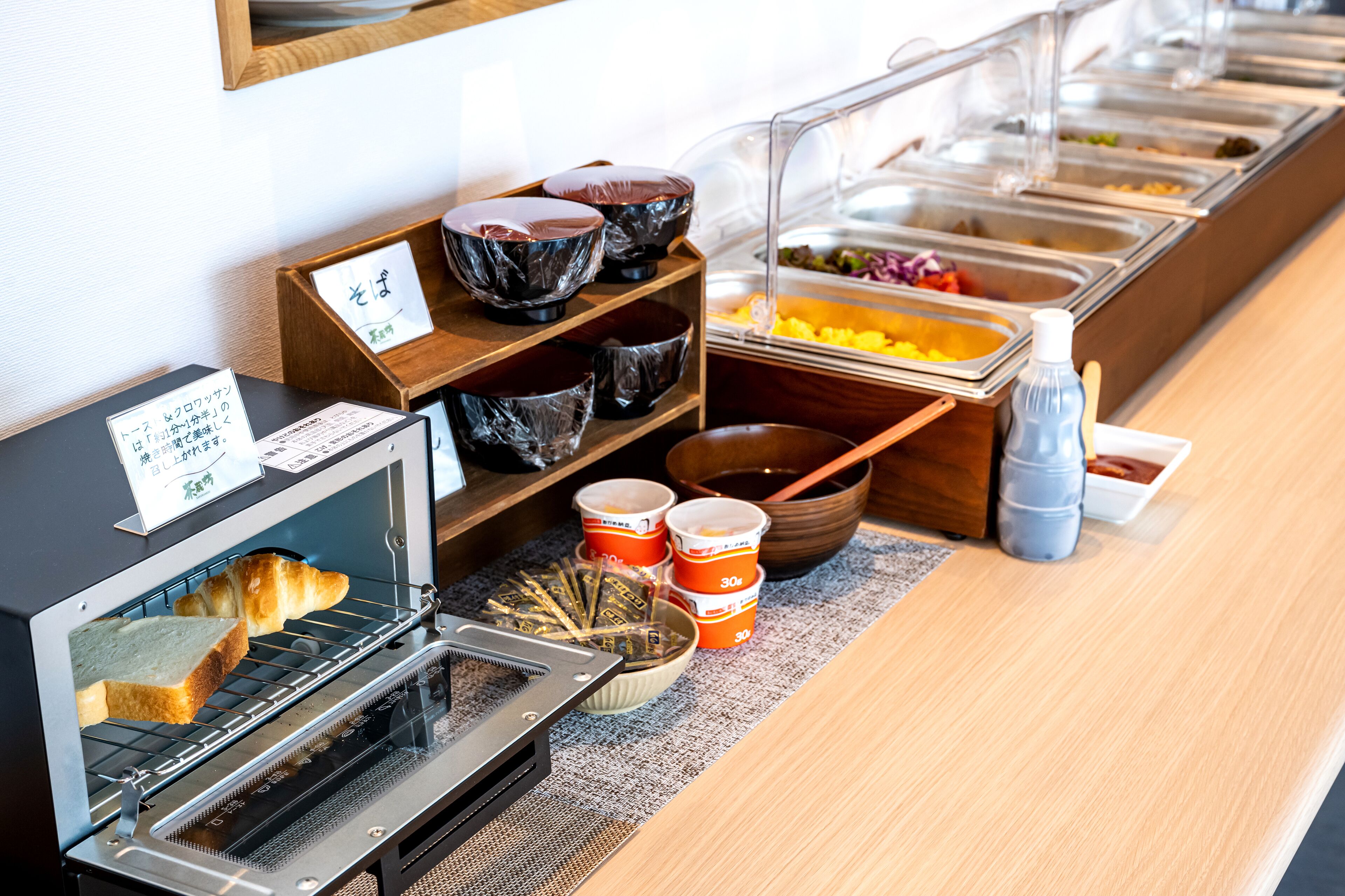 Disposición de un bufé con horno tostador, tazones y recipientes para condimentos.