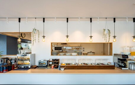 A modern breakfast bar with a variety of food containers, a coffee machine, and hanging plants.