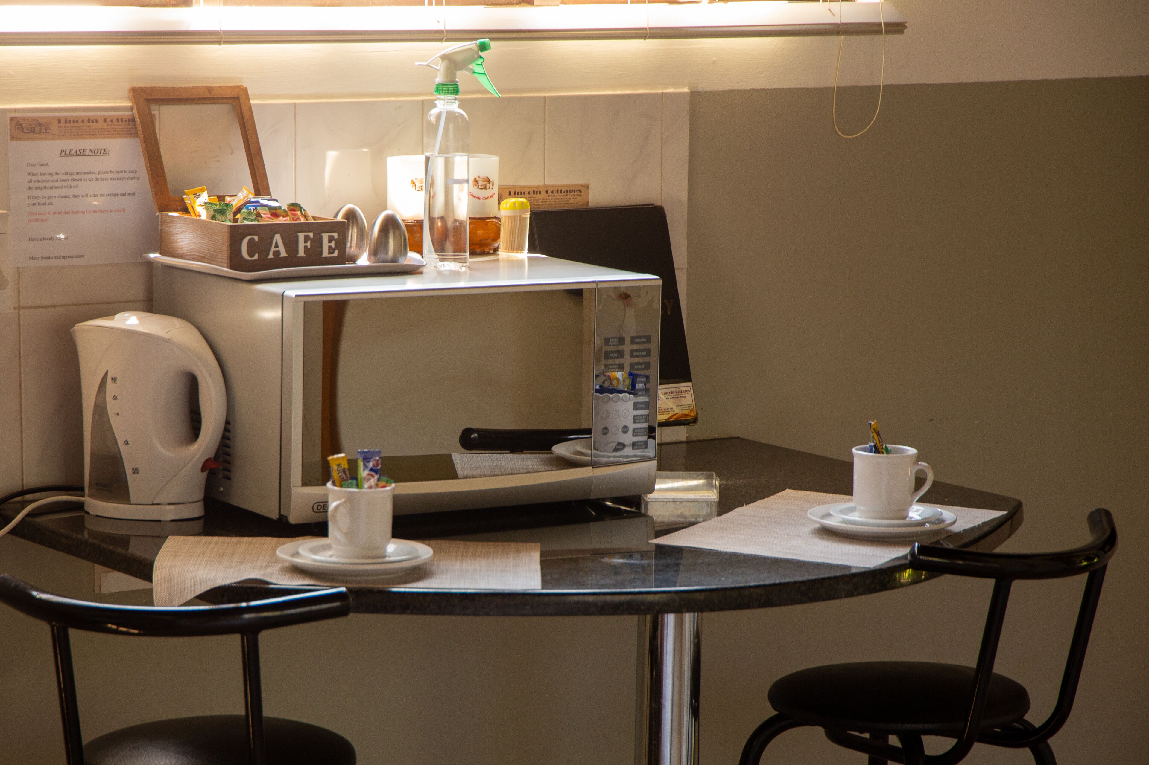 Una cafetería con una máquina de café, un dispensador de bebidas y un panel de menú.