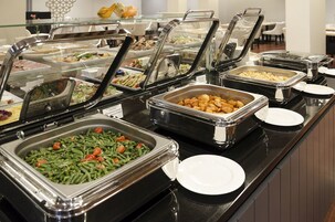 A buffet with various food options, including salads, meats, and vegetables.